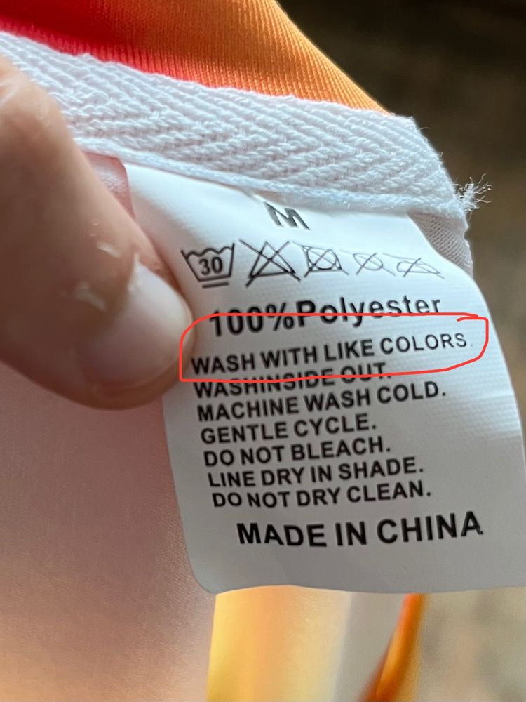 Tag in a t-shirt. It says 'wash with like colors'