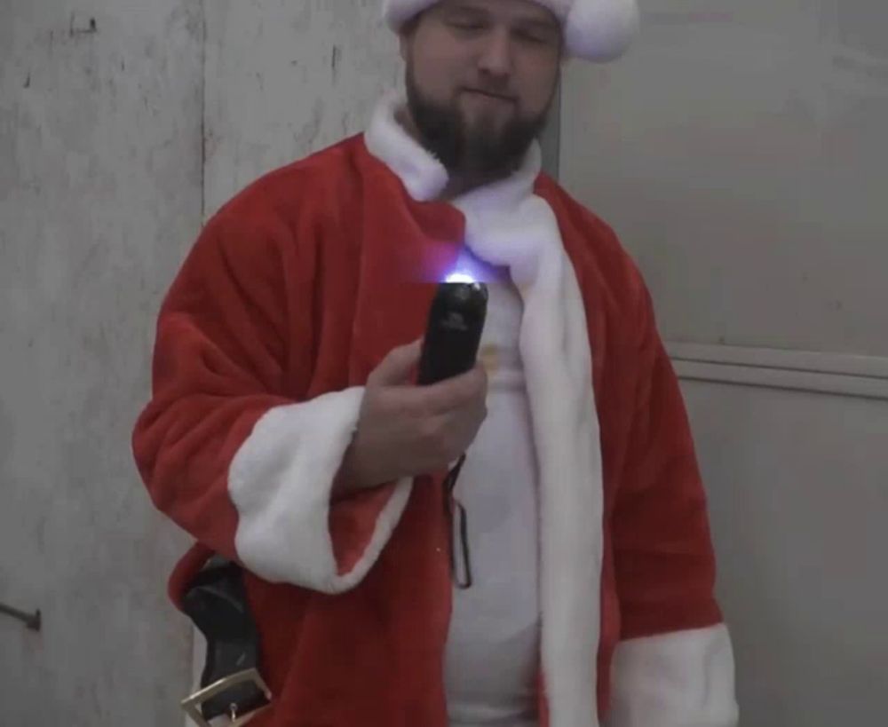 a man in a santa suit holds a flashlight