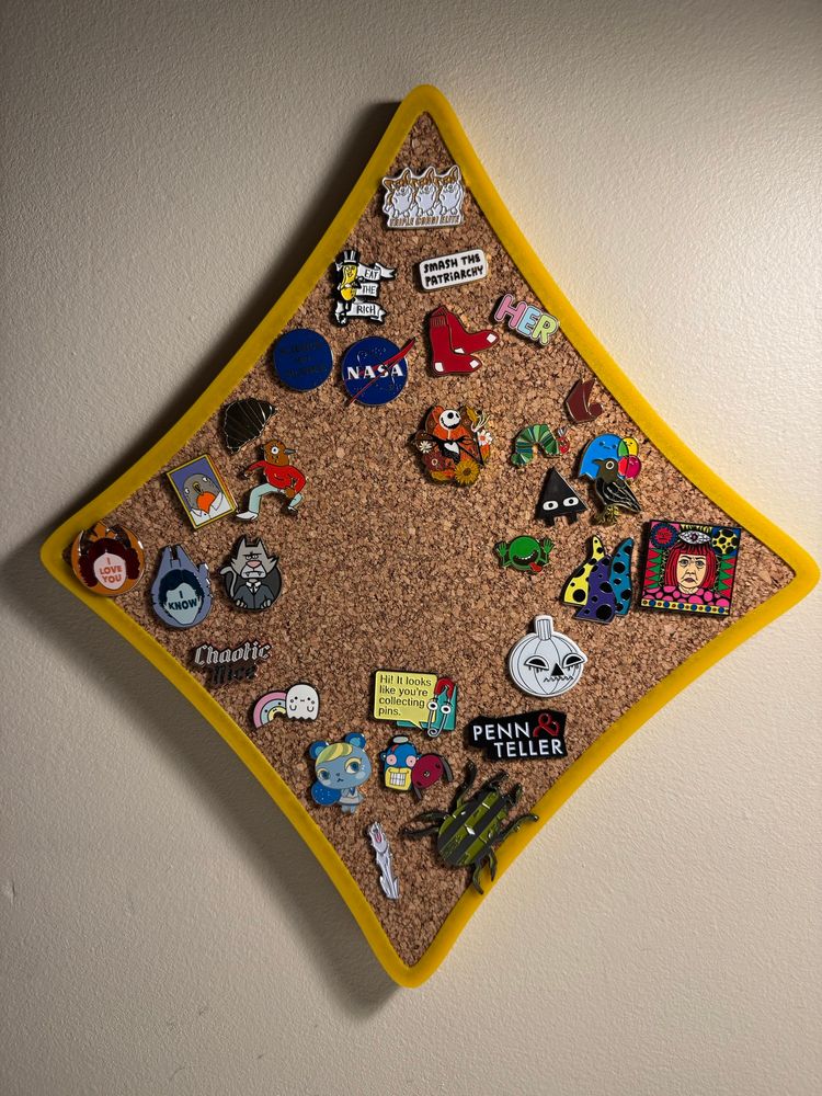 Assorted hard and soft enamel pins from Iris’ collection, featuring various intellectual properties and designs