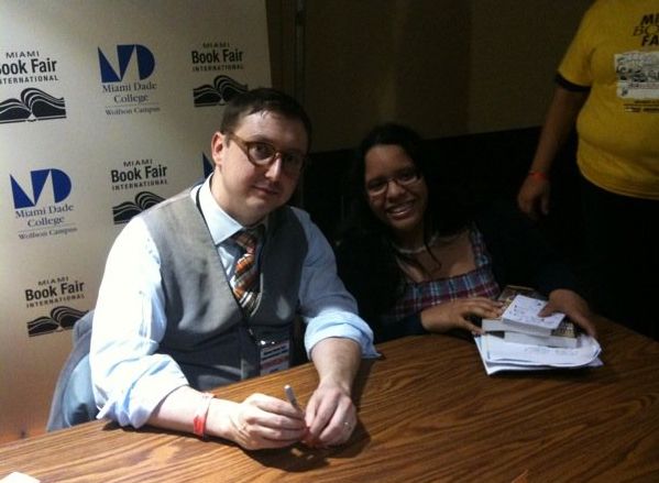 A beardless John Hodgman next to Iris in 2009 at the Miami Book Fair for a book signing.