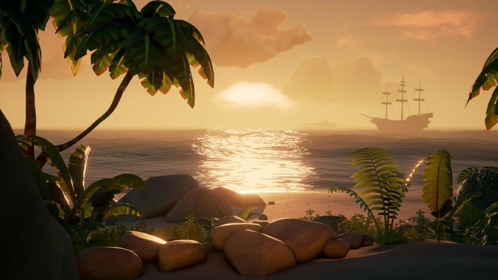 A beautiful sunset seen from the beach of a tropical island. A galleon is sitting out on the ocean.