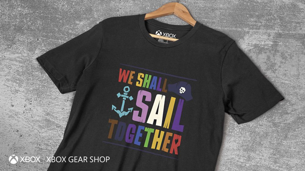 A black T-shirt with large, bold, colourful lettering saying "We Shall Sail Together", alongside an image of an anchor and a pirate hat.