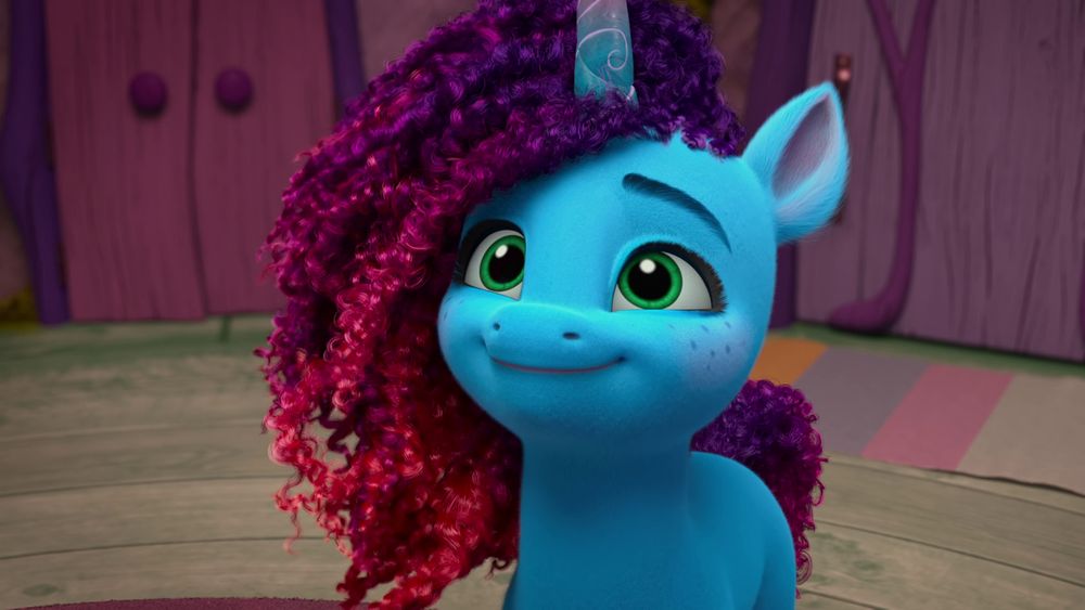 Misty Brightdawn from "My Little Pony: Make Your Mark". She is a cute blue unicorn with frizzy purple-red mane and tail, green eyes, and freckles.
