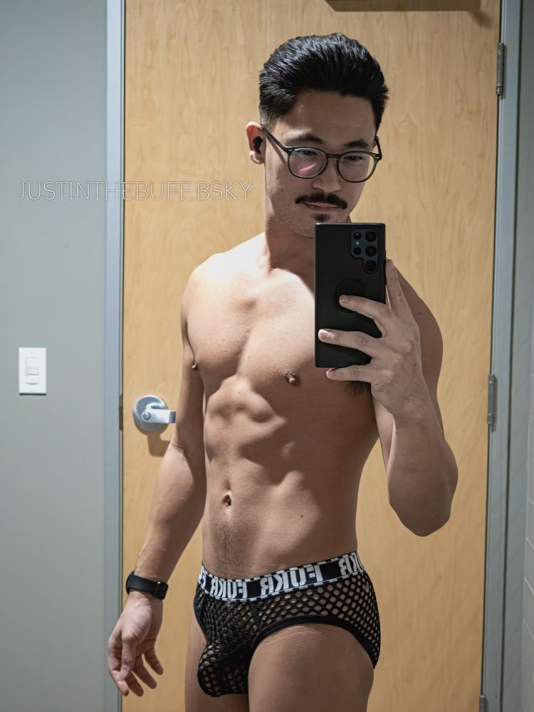 Justinthebuff is taking a picture in the mirror while wearing his mesh briefs