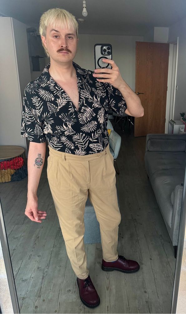 Mirror selfie of myself wearing a black leaf pattern shirt, beige trousers and red Doc Martens 
