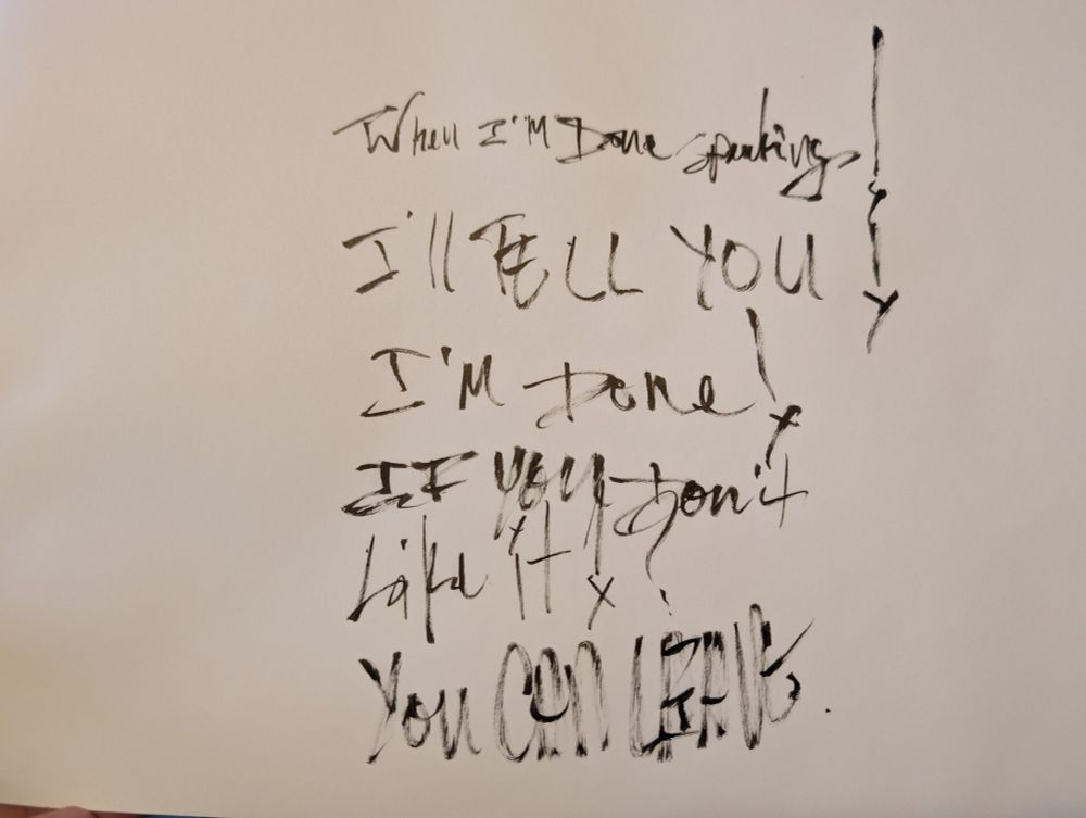 A photo of a black ink brush pen writing on white paper, "When I'm done speaking!
I'll tell you!
I'm done!
If you don't
Like it!?
YOU CAN LEAVE.
"