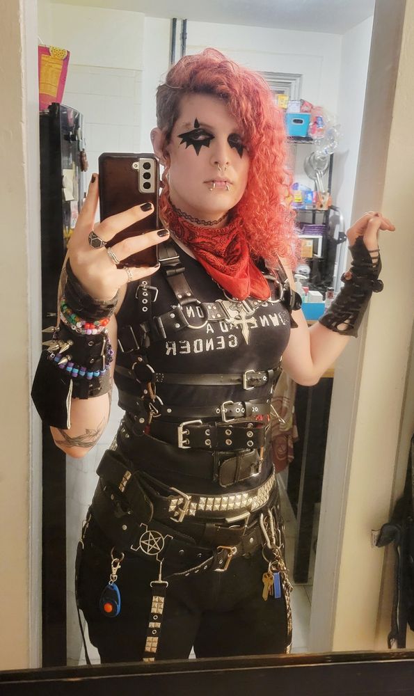 lilith (goth trans woman with red hair) looking very tired and yet somehow hot about about it (???) whilst standing in a doorway
