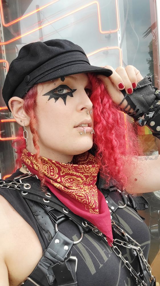 lilith (goth trans woman with red hair) in a black hat