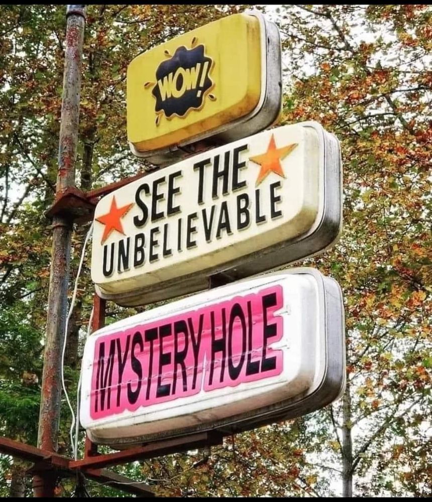 It's a photo of 3 outdoor signs one ontop of another the when strung together it reads "Wow! See the unbelievable  Mystery Hole"