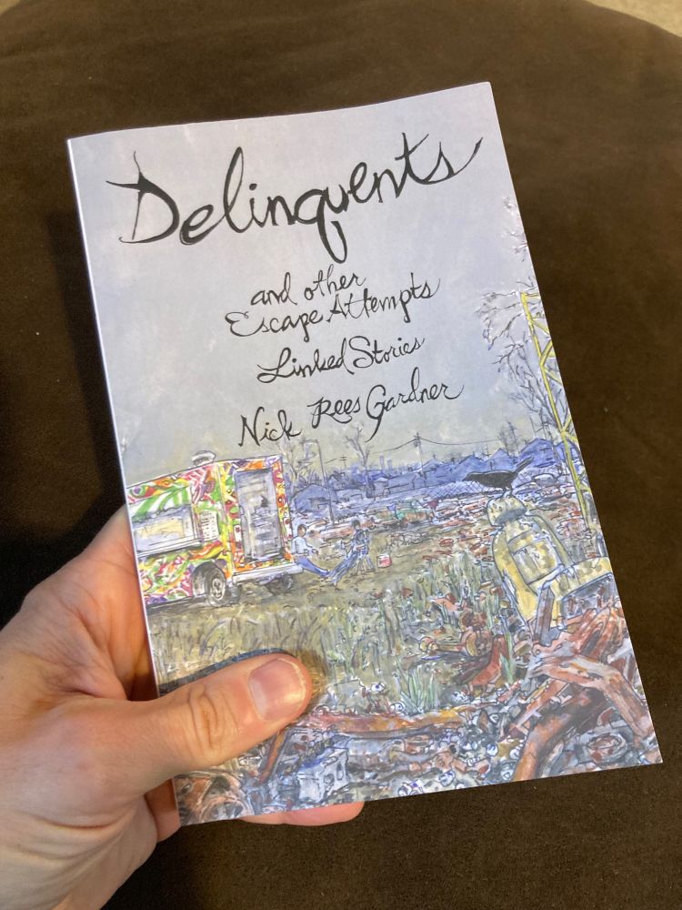 hand holding paperback of DELINQUENTS and other Escape Attempts, linked stories by Nick Rees Gardner