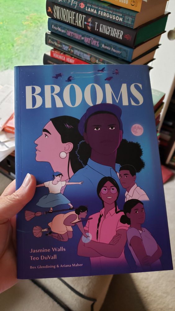 The cover of Brooms by Jasmine Walls, featuring a small group of women of Black, Indigenous, and Asian heritages, dressed in 1930s clothes against a blue background. Two of the characters are flying on broomsticks.