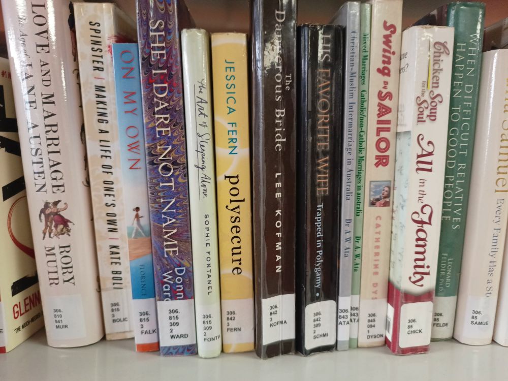 Selection of library books on a shelf, centred is Polysecure by Jessica Fern