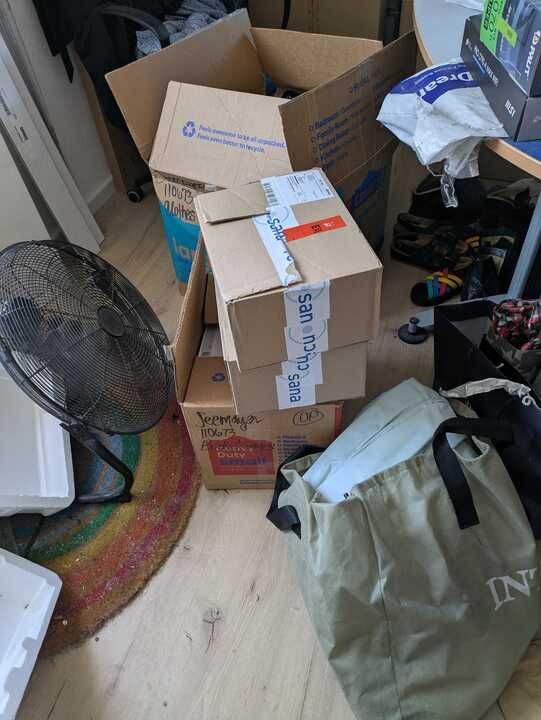 my worldly possessions - four boxes and an air mattress in a green bag. also a fan and things on the table that I do not own