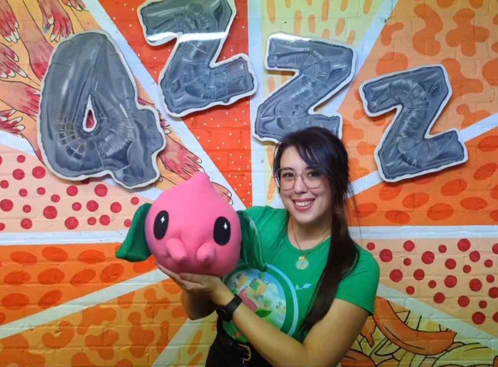 Photo of myself holding the Tempopo puppet I made under the 4ZZZ sign at their studio.