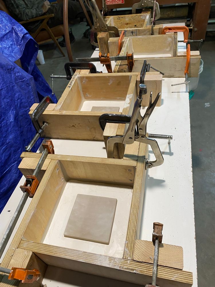 Tile blanks inside mold forms ready for plaster to be poured