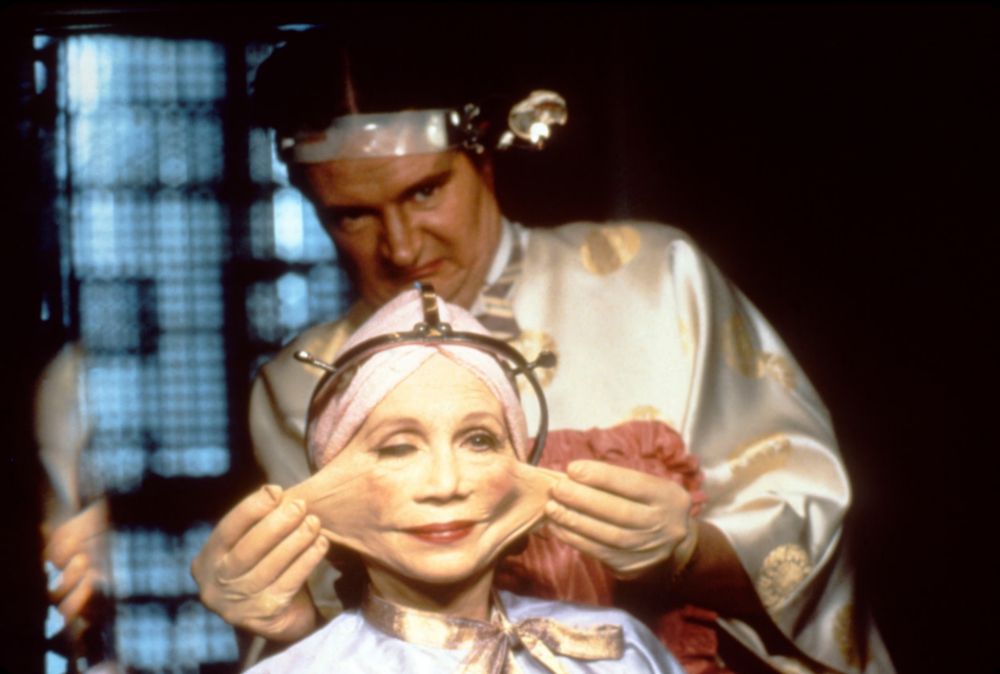 The facelift scene from the movie Brazil. Doctor is pulling rubber cheeks outward. 
