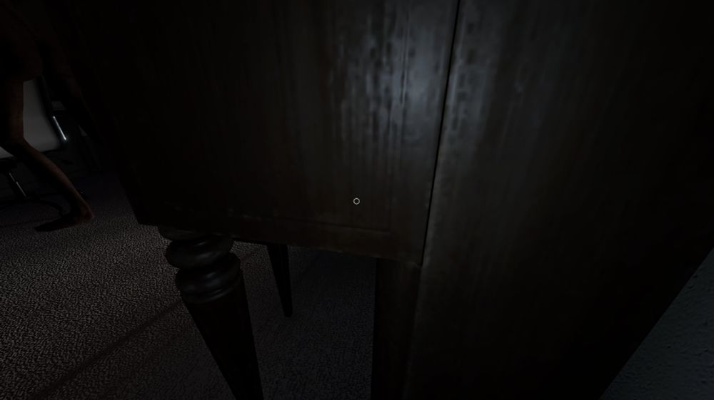 A screenshot from Phasmophobia in which I'm crouching between the side of a piano and a wall, and a hunting ghost's whole lower half is clearly visible in the frame