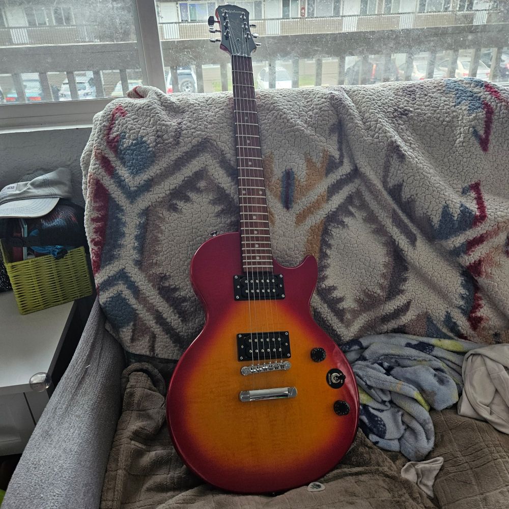 Epiphone Les Paul Special II heritage sunburst guitar. It's red with an orange burst in the center of the guitar