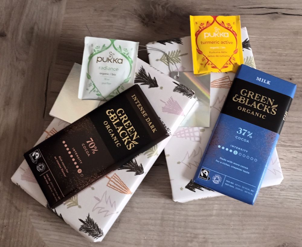 There are two books (they're the same book) wrapped up in festive wrapping paper. On top of each of them is a bar of chocolate and a pack of Pukka tea. If you join the Big Green Book Swap, you and a new online buddy will be matched up and you'll each get a book, some choc and a lovely cup of tea. 