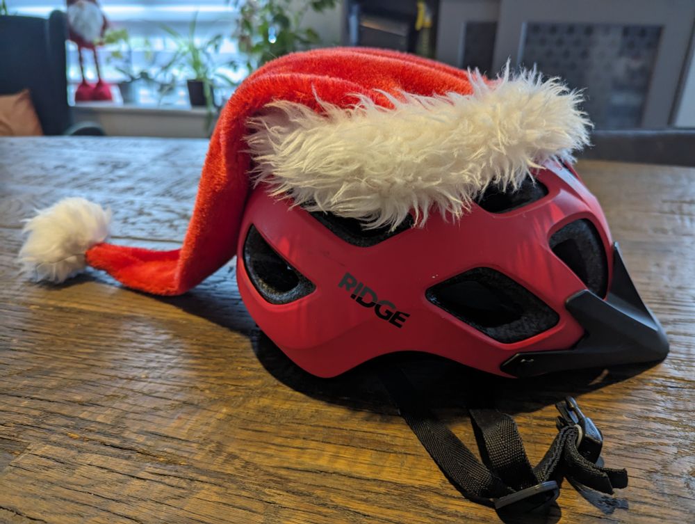 Bicycle helmet with Santa Claus hat attached. 