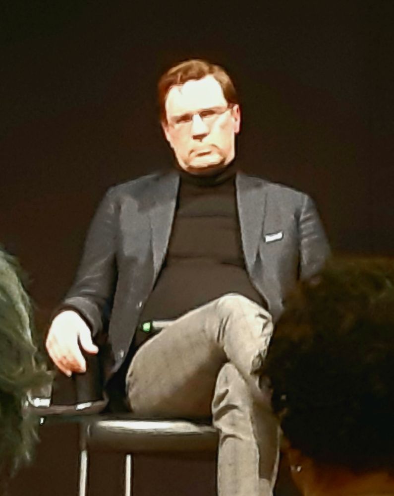 Sicherheitsexperte Nico Lange sitzt auf der Bühne im Scheinwerferlicht 