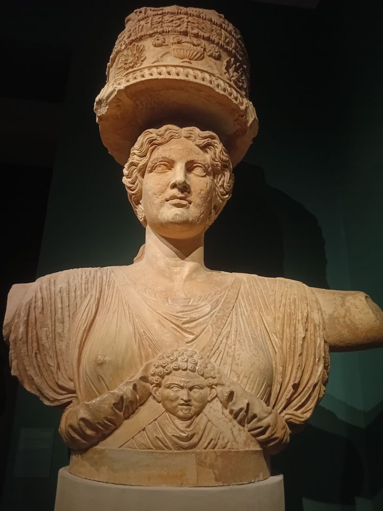 Front view of a statue of a woman holding up a column 
