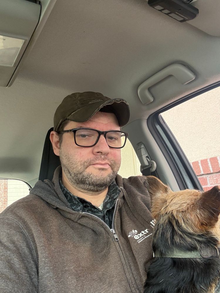 Evan is sitting in his car at the drive-thru. Ellie is looking out the window. 