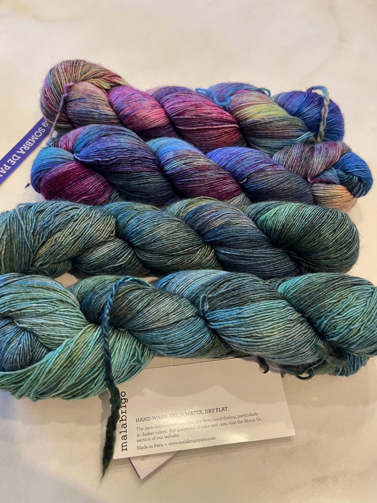 Four skeins of lace weight malabrigo yarn lay on a white countertop. They are 100% baby merino wool. Now to find a project that will do them justice 😍🧶