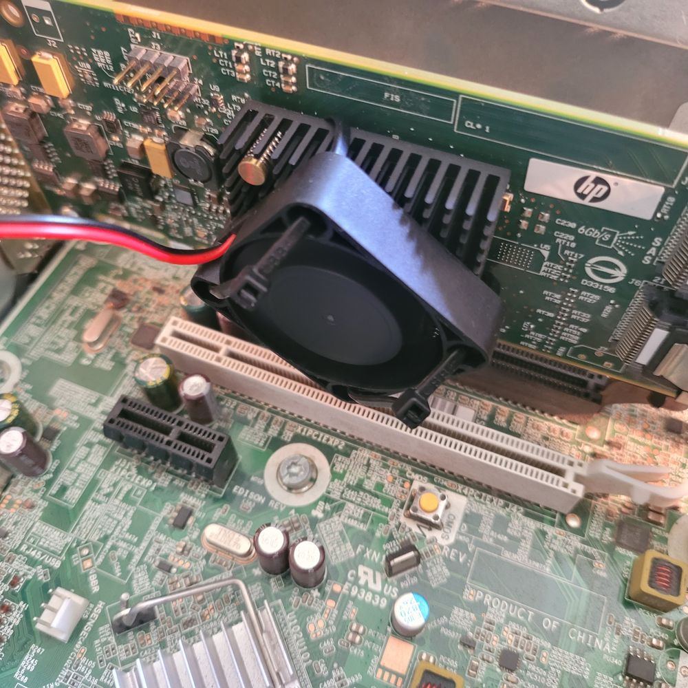 A fan zip-tied to a heat sync on a HBA card in a PC.