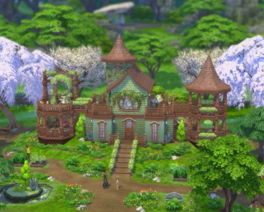 3 story green build with a stone tower, wooden gazebo towers on either side and lots of lush greenery.