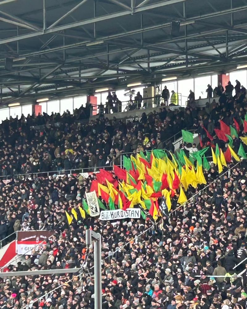 Fans des FC St. Pauli mit kurdischen Farben & dem Spruch „Bijî Kurdistan“