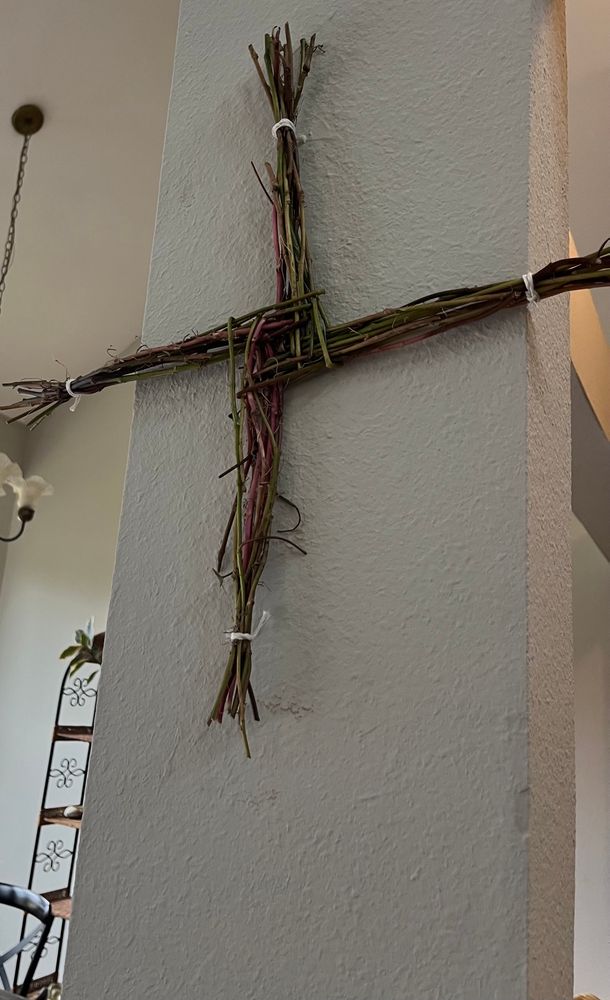 A st brigids cross woven from ivy hangs on a wall