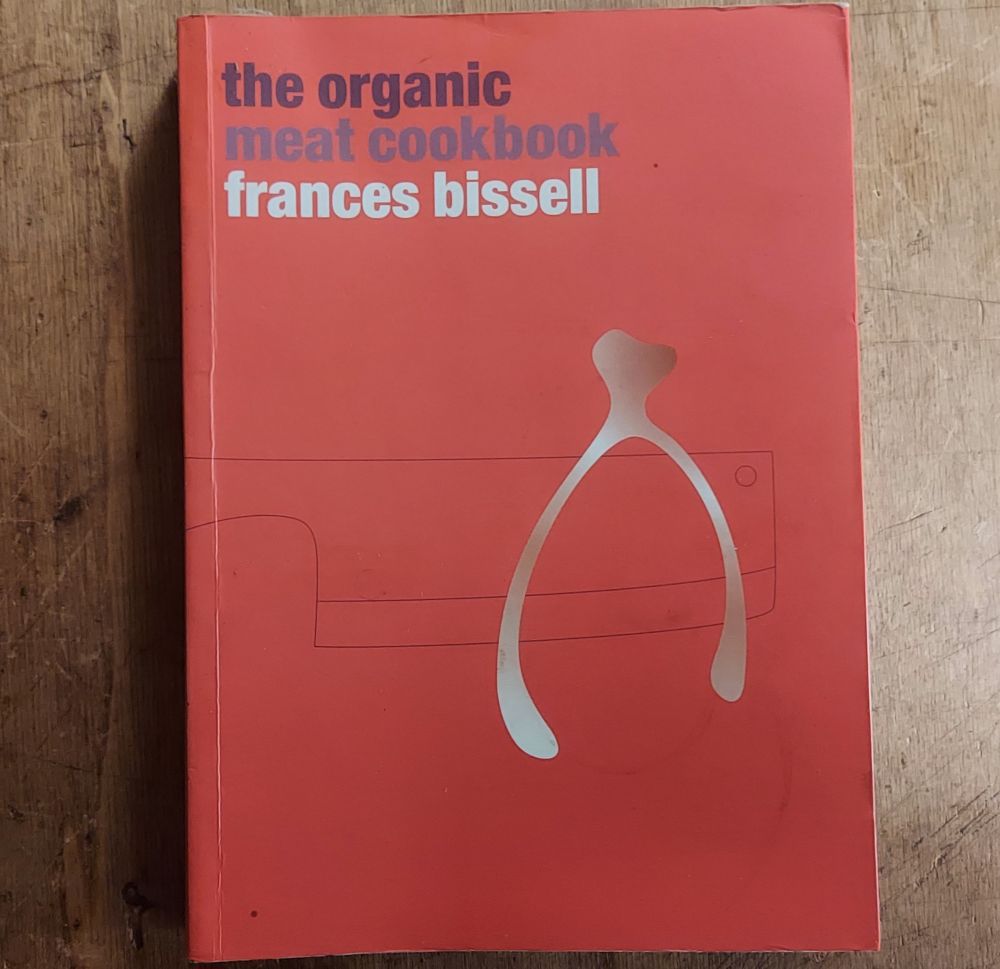 photo of a small red paperback book with the title The Organic Meat Cookbook by Frances Bissell