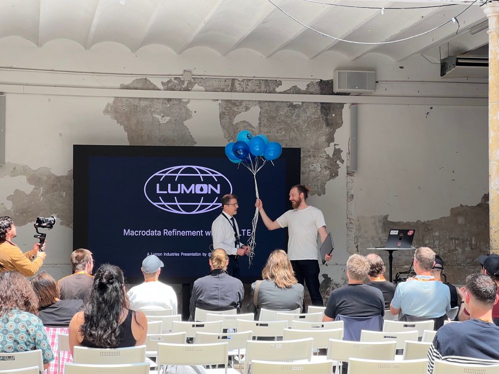 Ken Kunz presents Rich Harris with a bouquet of balloons at Svelte Summit in Barcelona.