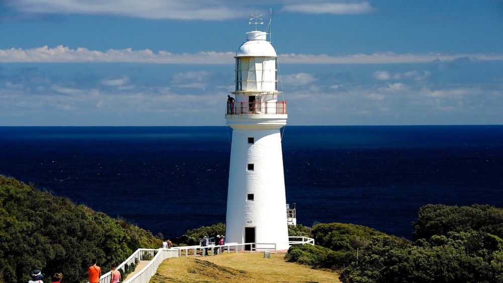 Photo of Cape Otway lighthouse. 

A gleaming white lighthouse standing tall against a background split between dark blue ocean and light blue sky. 