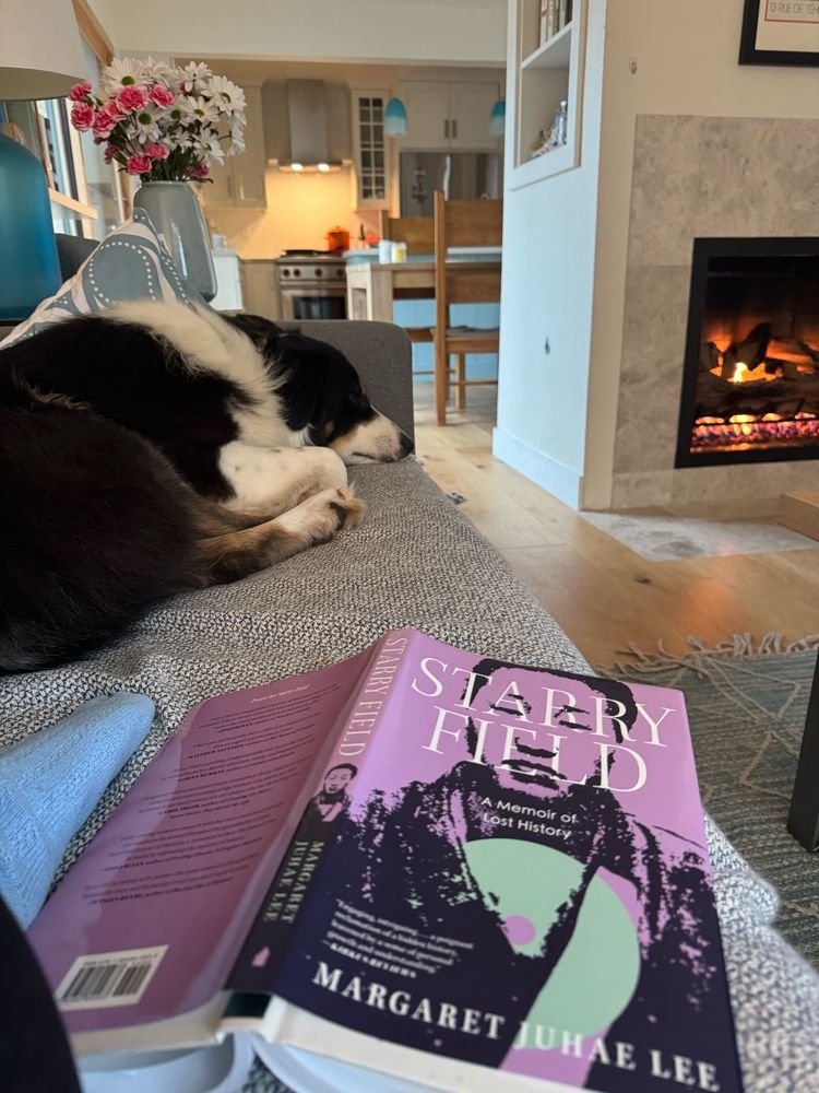 The cover of Margaret Juhae Lee’s STARRY FIELD memoir in front of a fireplace