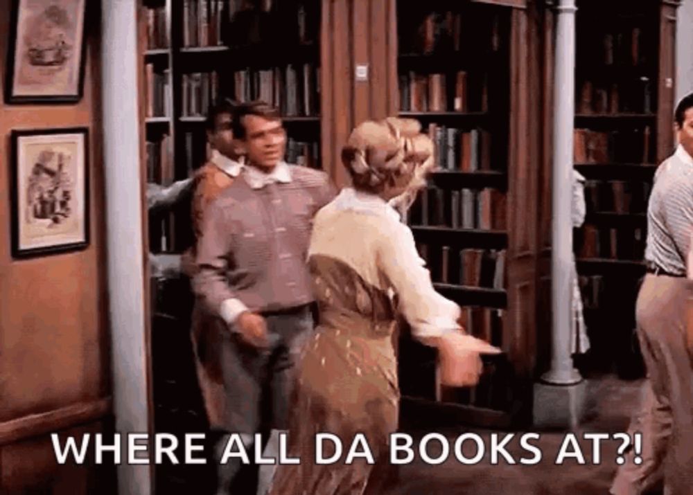 a man and a woman are dancing in a library and the woman is pointing at the man and saying where all da books at .