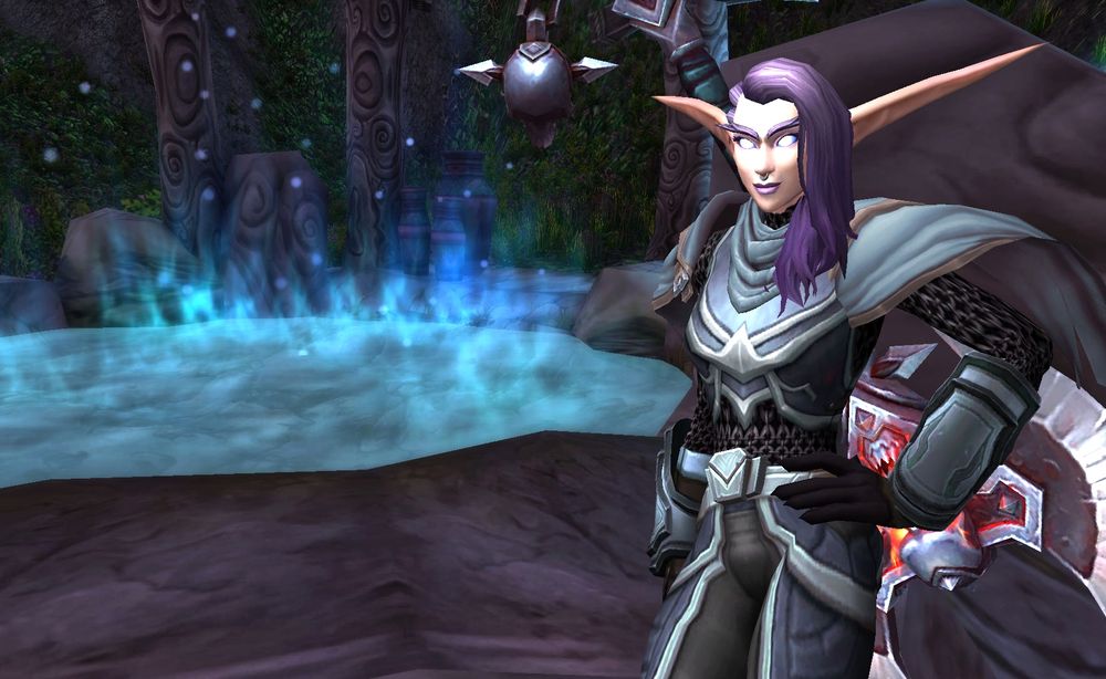 A purpled haired night elf warrior with pink skin leaning against a rock next to a moonwell wearing a chainmail armor set and double headed axe. 
