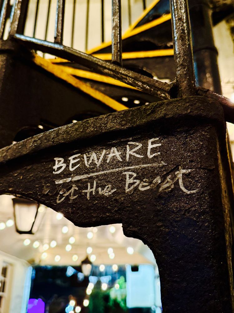 Une inscription sur un escalier métallique : « Beware of the beast »
