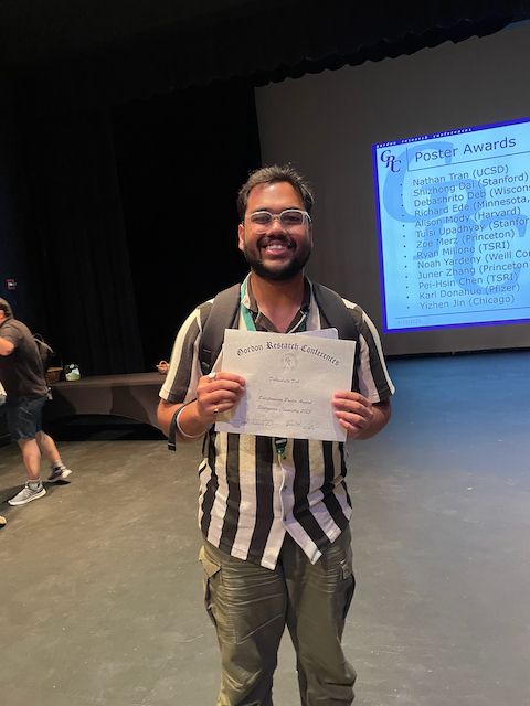 Debashrito Deb holding up his poster award at the 2025 Bioorganic GRC
