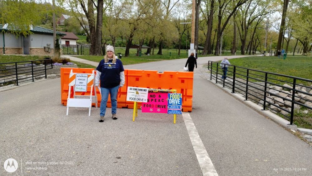 A volunteer directing donors to the drop off location in the park. 