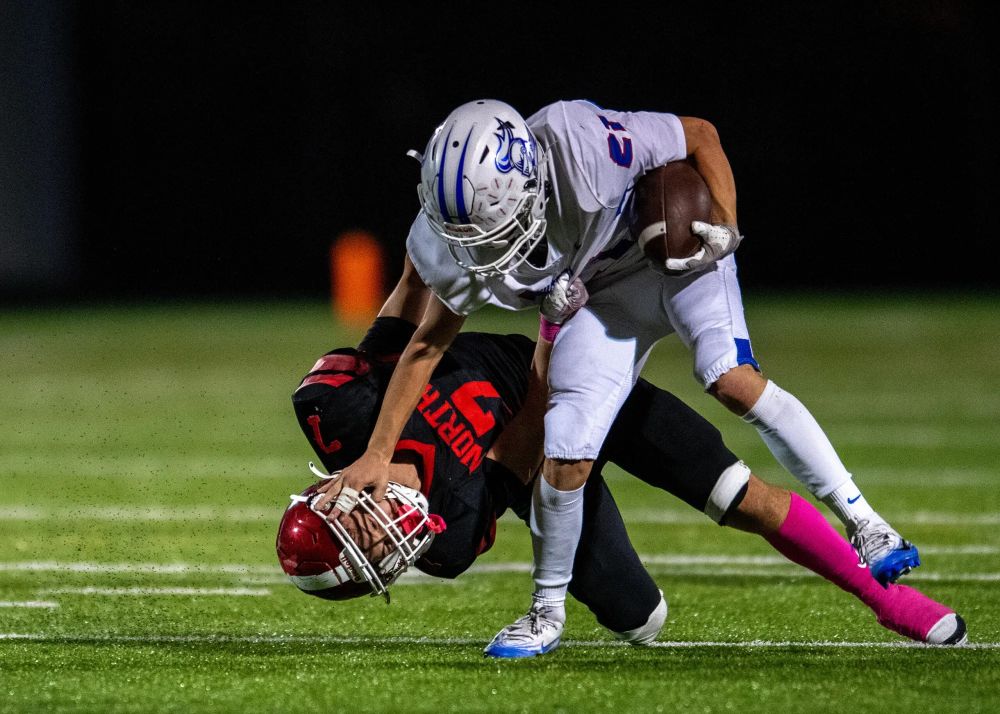 Running back Asa Krebs of the Churchill Lancers stiff-arms linebacker Josiah Corsini of the North Eugene Highlanders at North Eugene High School in Eugene, Oct. 10, 2025. The Lancers won, 36-6. Credit: Kalani Chai-Andrade / For Lookout Eugene-Springfield