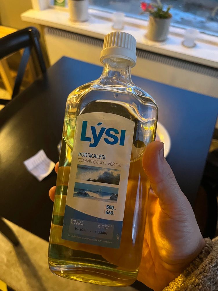Hand holding a bottle of Lysi cod-liver oil 