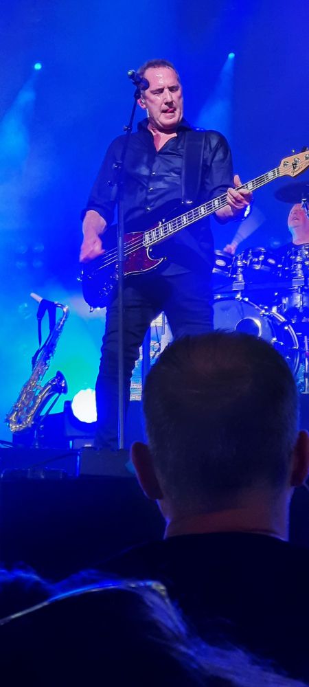 Andy McCluskey of Orchestral Manoeuvres In The Dark, playing a guitar.