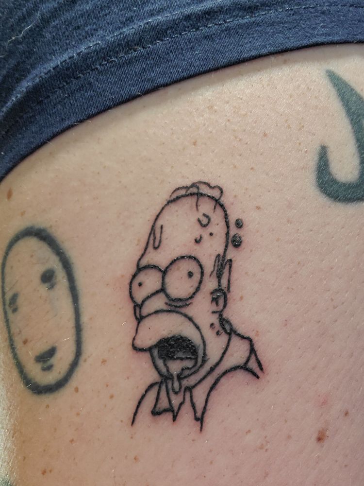 Tattoo of an infected Homer Simpson on Friday the 13th next to a No Face tattoo.
