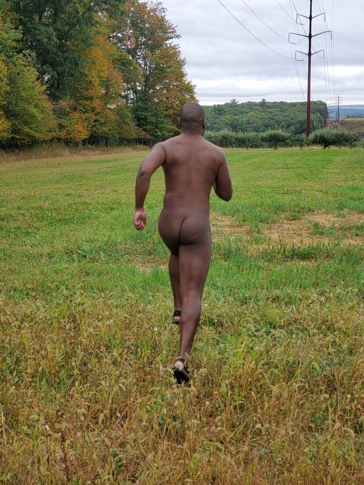 Rear pov of nude b8rjay running through a field during a hike