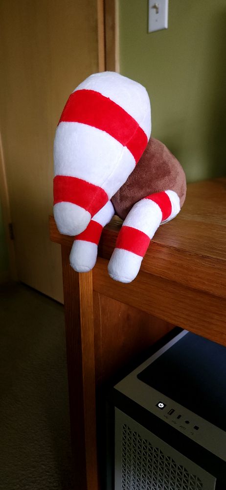 Signalis storch plush on edge of desk