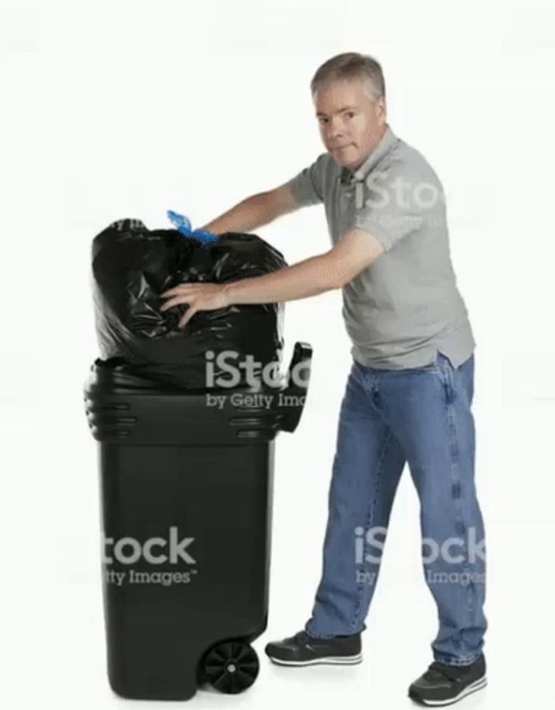 a man is putting a trash bag into a garbage can .