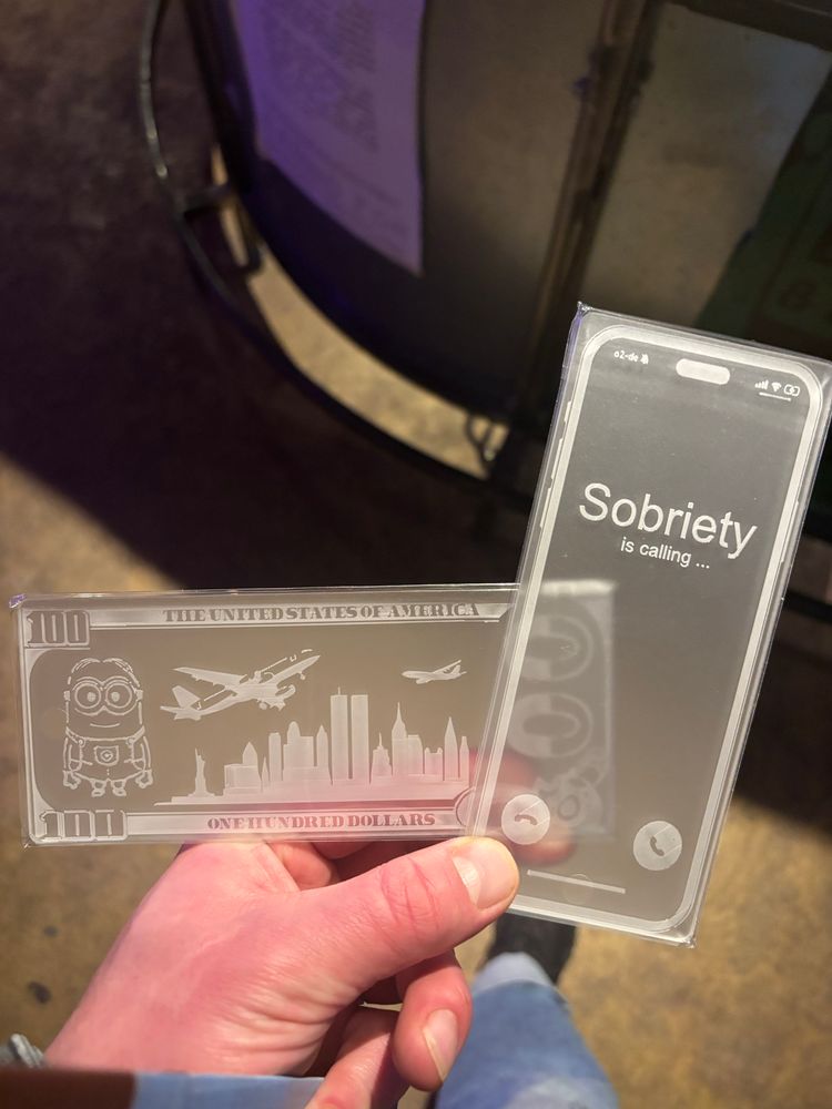 some cards for crushing uhhhh salts; one of them has a print on it that resembles a smartphone with an incoming call, the caller id is “Sobriety”. the other is a hundred dollar bill with a minion on it and a new york city skyline back when those big ole towers were still there, with two planes hovering over it. magnificent