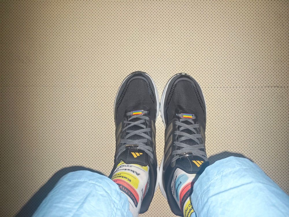 Adidas Laufschuhe mit Regenbogenbadge auf den Schnürsenkeln